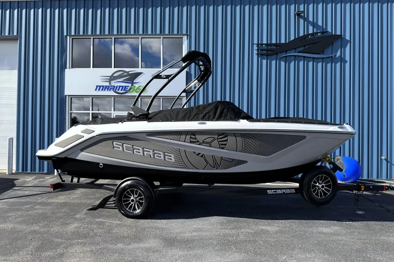 Slide: The Image of 2026 Scarab 210 LX boat on trailer, parked outside Marine 365 building. - 8