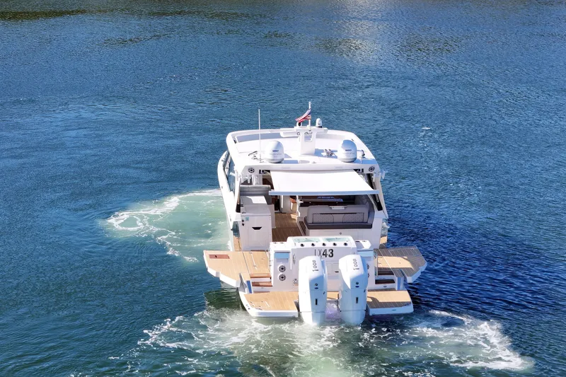 Slide: The Image of 2025 Regal LX43 luxury boat cruising on clear blue water. - 12