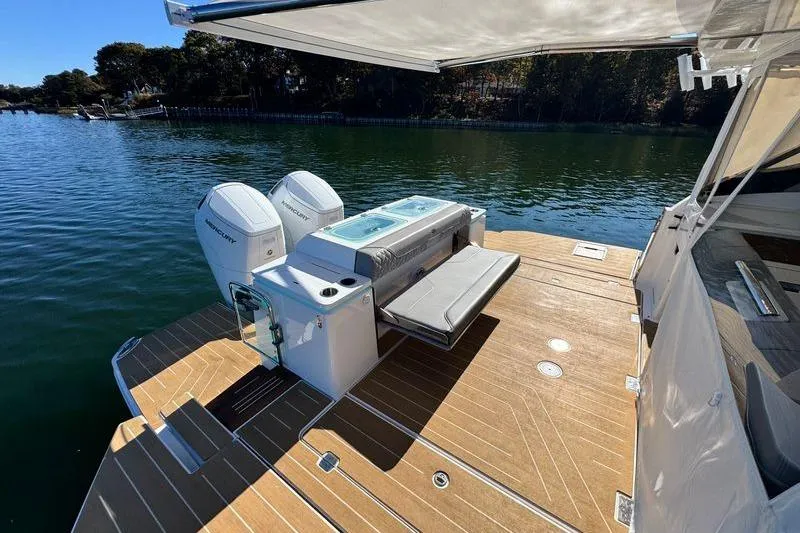 Slide: The Image of 2025 Regal LX43 boat deck with dual Mercury engines on a serene lake. - 17