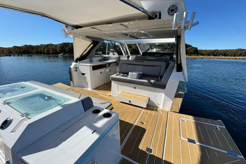 Slide: The Image of Luxurious 2025 Regal LX43 boat interior with seating, open deck, and scenic water view. - 25