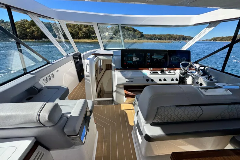 Slide: The Image of 2025 Regal LX43 yacht interior with modern helm, luxurious seating, and panoramic windows. - 36