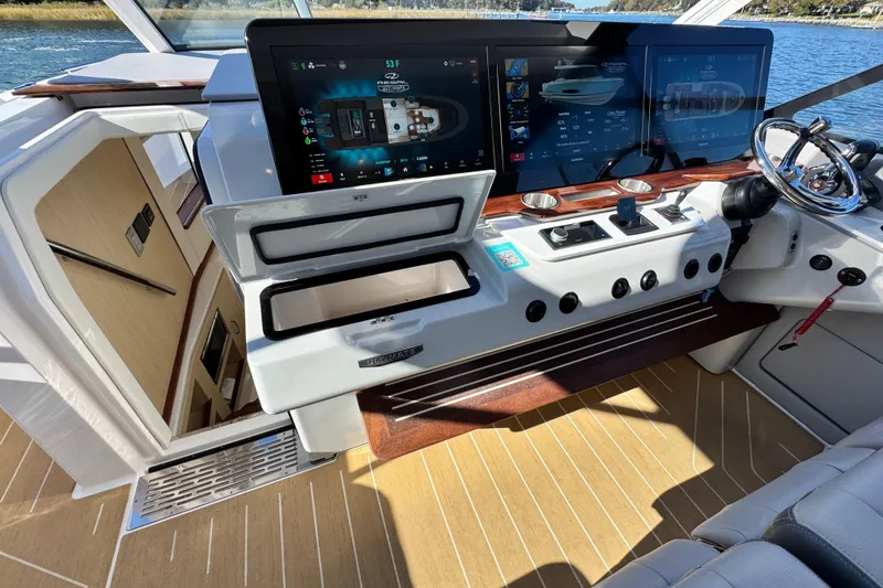 Slide: The Image of Helm of 2025 Regal LX43 boat with advanced navigation screens and controls. - 39