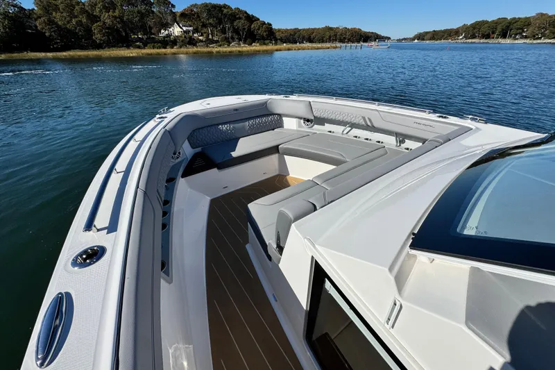 Slide: The Image of 2025 Regal LX43 boat with spacious seating on a serene lake. - 54