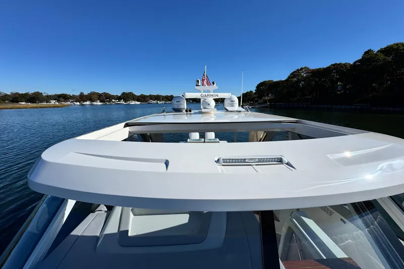 Slide: The Image of 2025 Regal LX43 yacht on calm water, showcasing sleek design and advanced navigation equipment. - 57