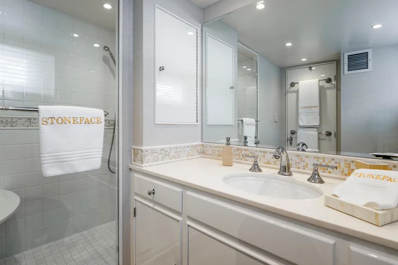 Slide: The Image of Modern bathroom with white tiles, dual sinks, and "STONEFACE" branded towels. - 23