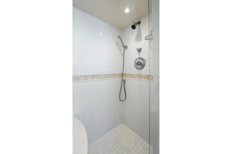 Slide: The Image of Modern shower with white tiles, mosaic accent, and chrome fixtures in a 1978 Burger Custom. - 24