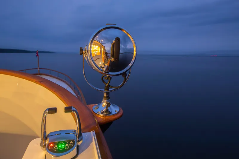 Slide: The Image of Vintage 1978 Burger Custom yacht spotlight reflecting serene ocean at dusk. - 40