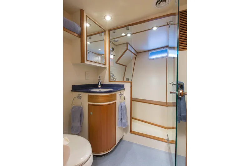 Slide: The Image of Luxurious yacht bathroom with wooden cabinetry, glass shower, and modern fixtures, 1978 Burger Custom. - 48