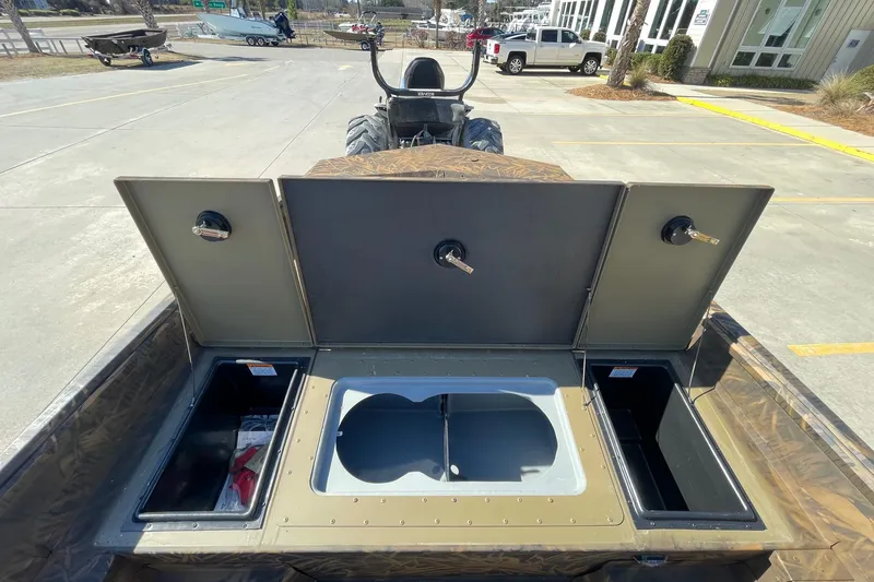 Slide: The Image of 2026 G3 Gator Tough 17 CC boat storage compartments open in a parking lot. - 13
