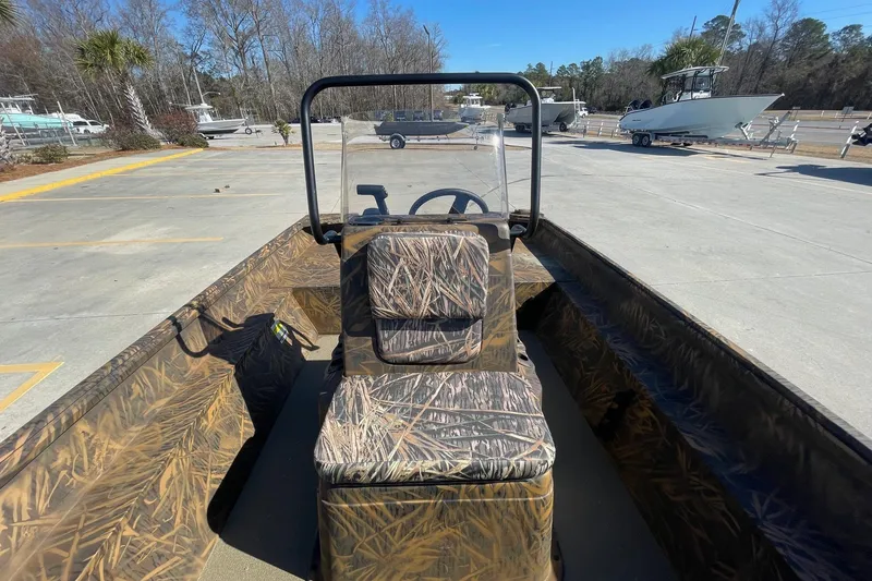 Slide: The Image of 2026 G3 Gator Tough 17 CC boat with camouflage interior, parked outdoors. - 11