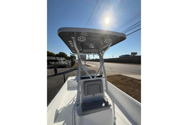 Slide: The Image of 2026 Blazer Bay 2400 boat with T-top under sunny sky, parked on roadside. - 27