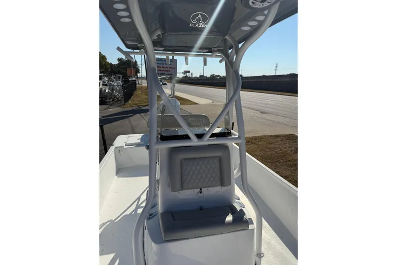 Slide: The Image of 2026 Blazer Bay 2400 boat with T-top, parked on roadside, showcasing interior seating. - 28