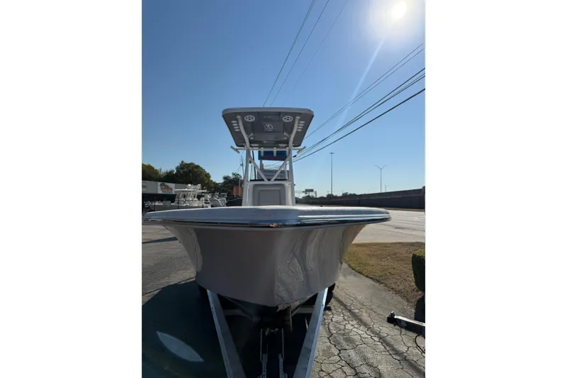 Slide: The Image of 2026 Blazer Bay 2400 boat on trailer under clear blue sky. - 3