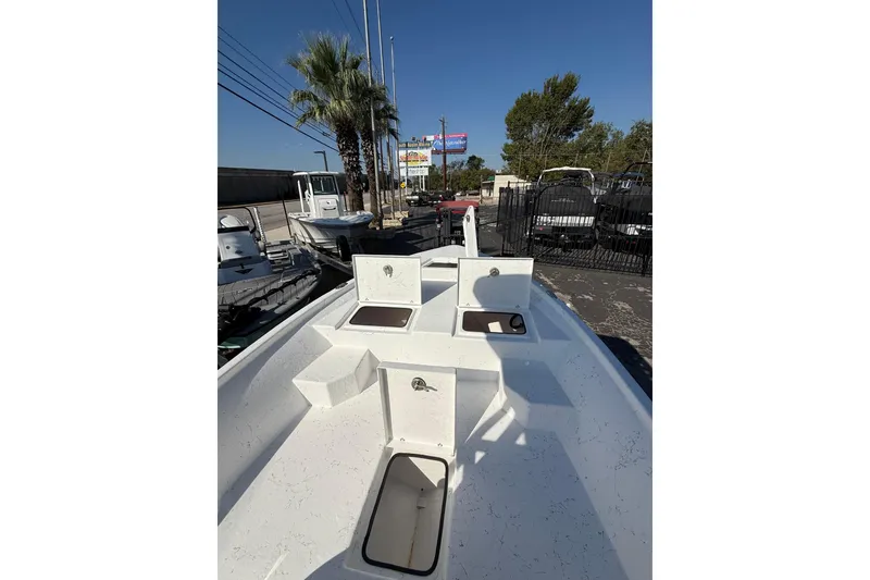 Slide: The Image of 2026 Blazer Bay 2400 boat deck with storage compartments, parked outdoors. - 32