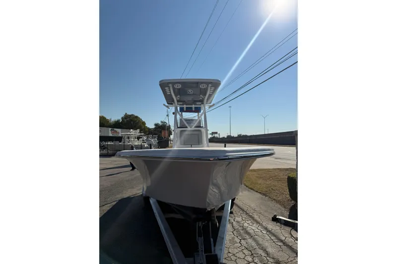 Slide: The Image of 2026 Blazer Bay 2400 boat on trailer under clear blue sky. - 37