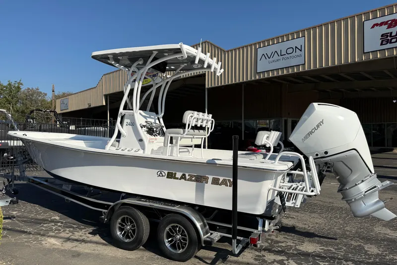Slide: The Image of 2026 Blazer Bay 2400 boat with Mercury engine on trailer, parked outside dealership. - 6