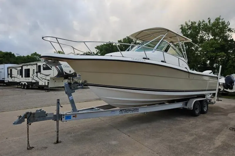 The Image of 2001 Pursuit 2870 Walkaround boat on trailer, parked outdoors. - 0