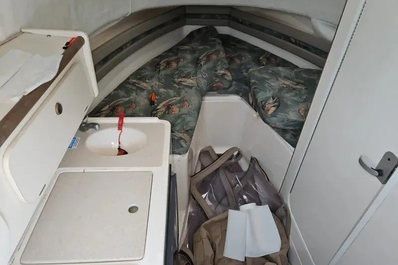 Slide: The Image of 2001 Pursuit 2870 Walkaround cabin interior with sink and patterned bedding. - 10