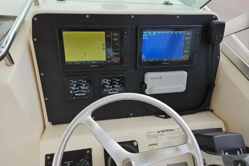 Slide: The Image of 2001 Pursuit 2870 Walkaround boat dashboard with navigation and control systems. - 11