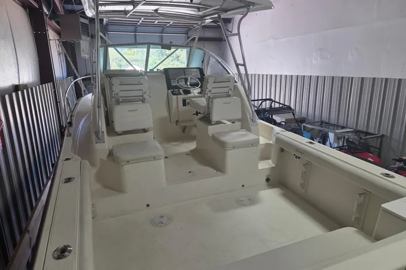 Slide: The Image of 2001 Pursuit 2870 Walkaround boat interior with seating and steering wheel in storage. - 14