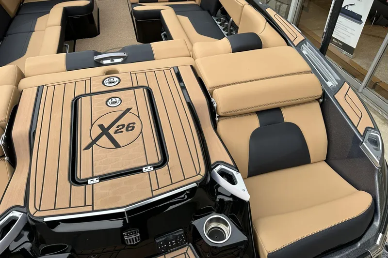 Slide: The Image of 2021 MasterCraft X26 boat interior with tan and black seating, showcasing luxury design. - 13