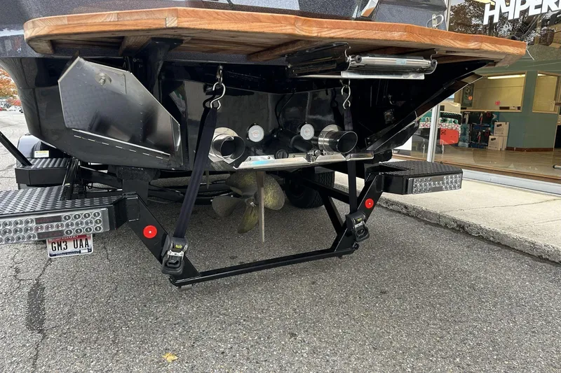 Slide: The Image of Rear view of a 2021 MasterCraft X26 boat on a trailer, showcasing propeller and exhaust. - 16