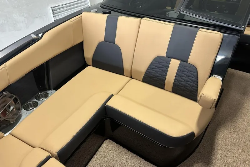 Slide: The Image of 2021 MasterCraft X26 boat interior with tan and black seating, cup holders, and sleek design. - 3