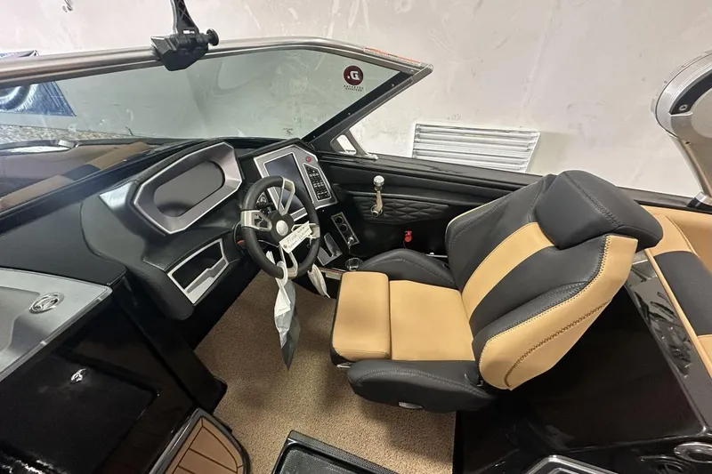 Slide: The Image of 2021 MasterCraft X26 interior with tan and black seating, luxurious design. - 5