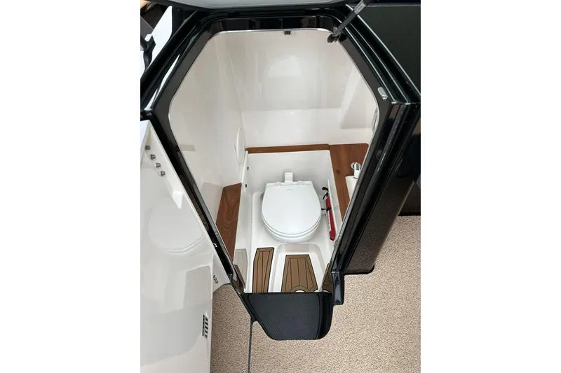 Slide: The Image of 2021 MasterCraft X26 boat interior with compact bathroom and toilet. - 7
