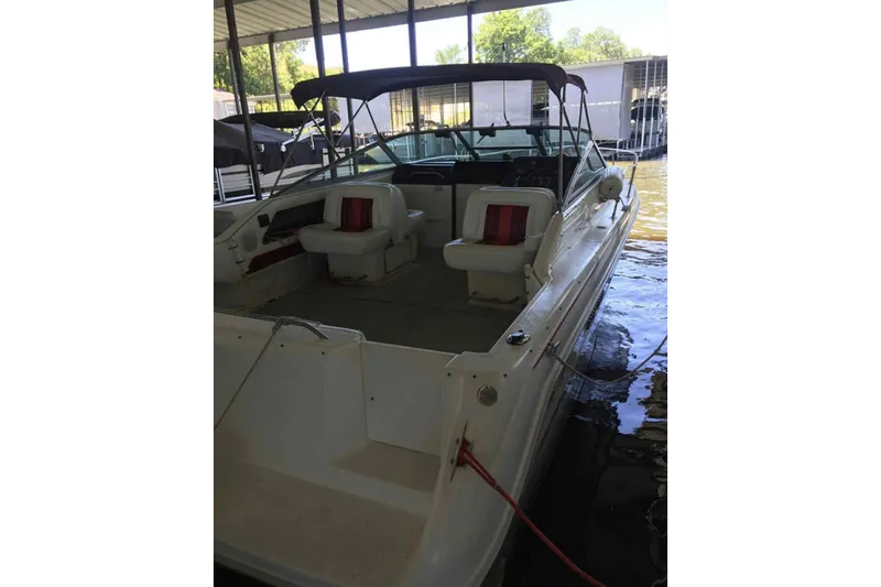 Slide: The Image of 1992 Sea Ray 300 Weekender boat docked, featuring spacious seating and canopy. - 1