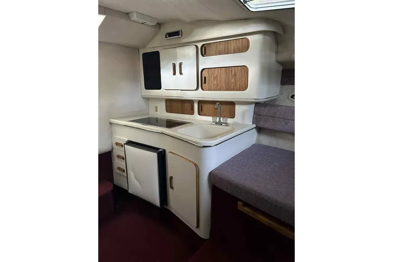 Slide: The Image of 1992 Sea Ray 300 Weekender cabin interior with kitchenette, featuring sink and storage cabinets. - 6