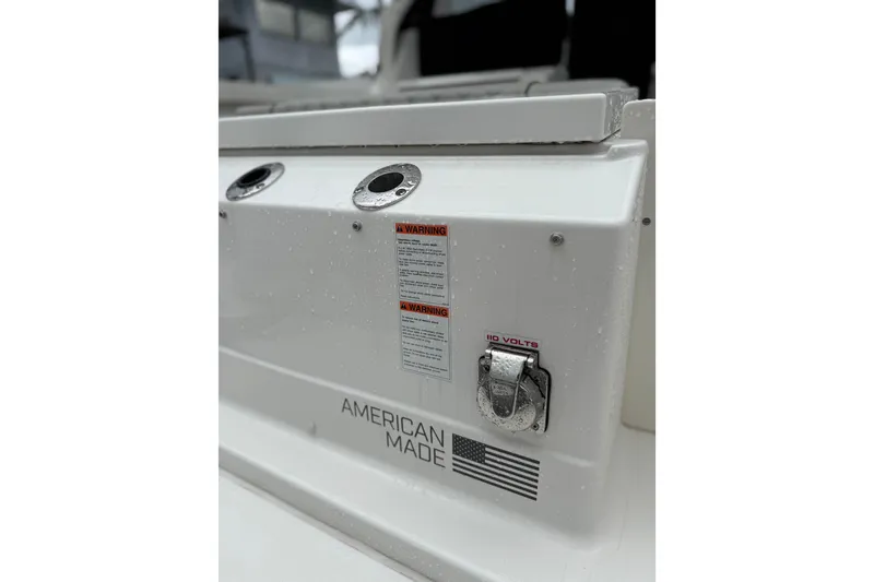 Slide: The Image of 2025 Pursuit OS 325 Offshore boat detail with American flag and warning labels. - 11