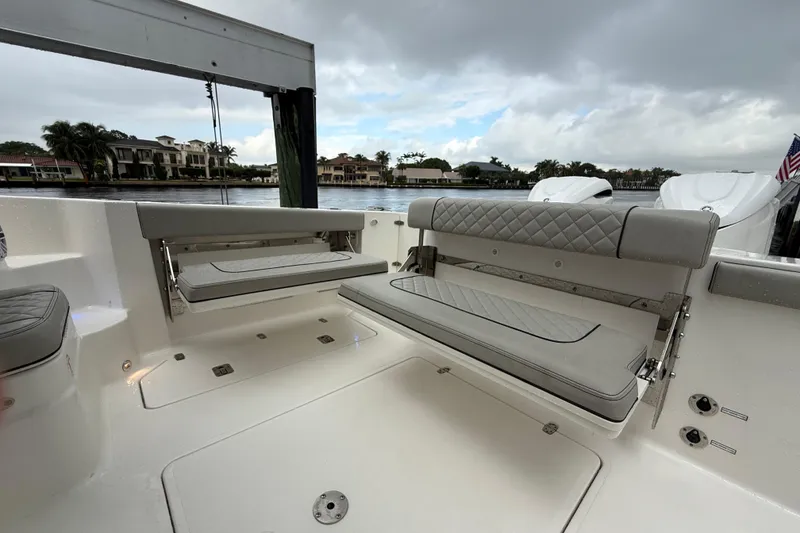Slide: The Image of 2025 Pursuit OS 325 Offshore boat interior with cushioned seating and waterfront view. - 17