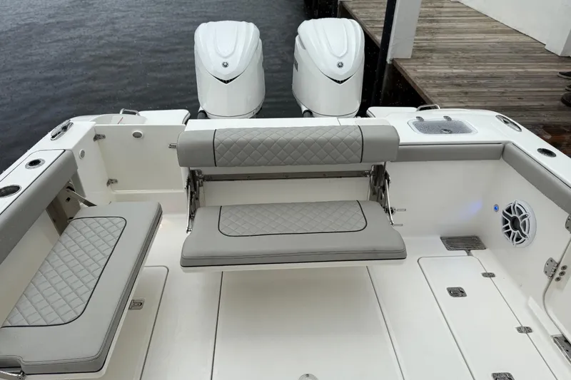Slide: The Image of 2025 Pursuit OS 325 Offshore boat interior with cushioned seating and dual engines. - 18