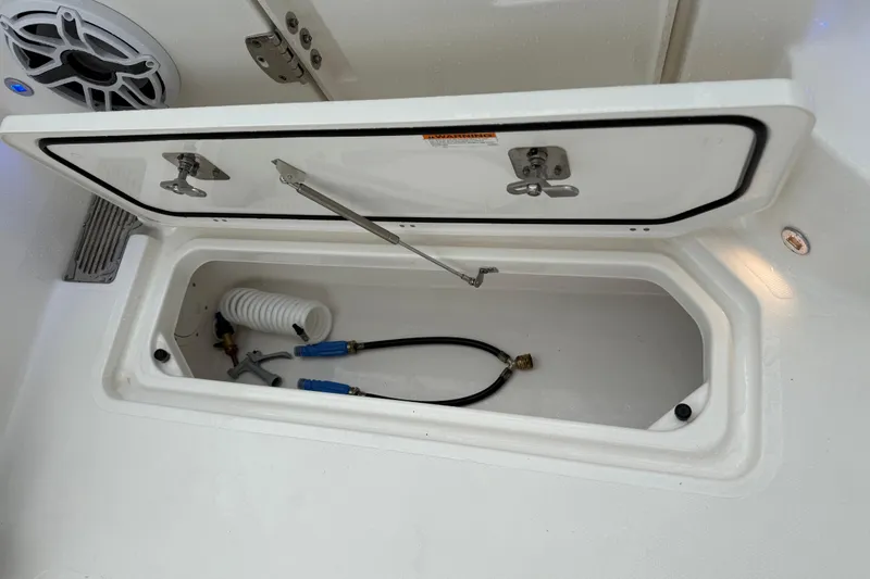Slide: The Image of Storage compartment of 2025 Pursuit OS 325 Offshore boat with hoses and fittings. - 22