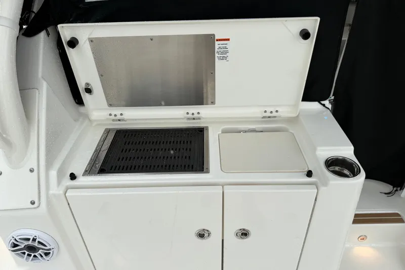 Slide: The Image of 2025 Pursuit OS 325 Offshore boat kitchen area with grill and storage. - 23