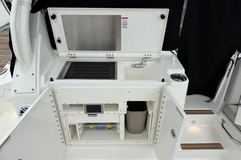 Slide: The Image of 2025 Pursuit OS 325 Offshore boat galley with sink, storage, and grill. - 24