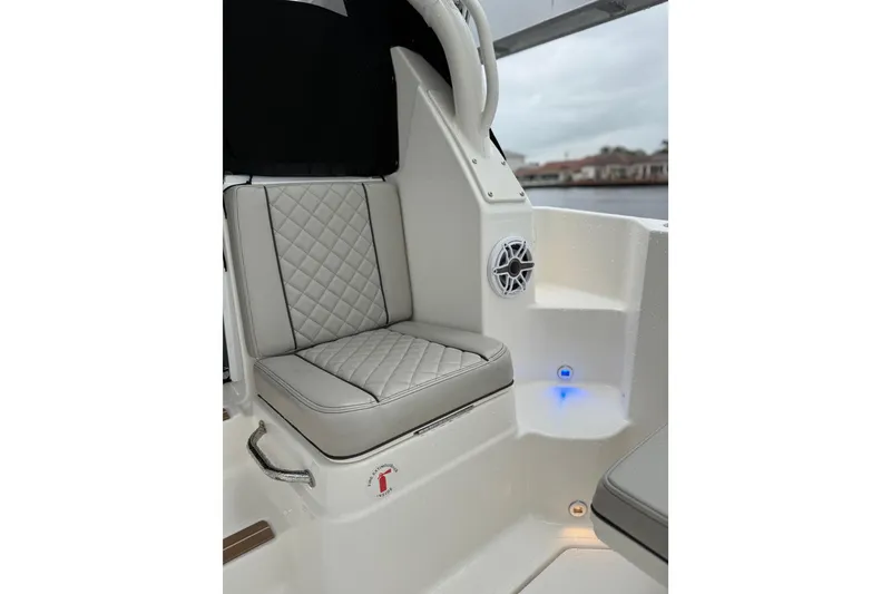 Slide: The Image of 2025 Pursuit OS 325 Offshore boat interior with cushioned seating and speaker. - 26