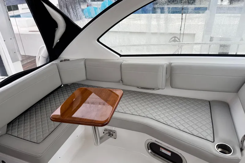 Slide: The Image of Luxurious interior of 2025 Pursuit OS 325 Offshore boat with quilted seating and wooden table. - 28