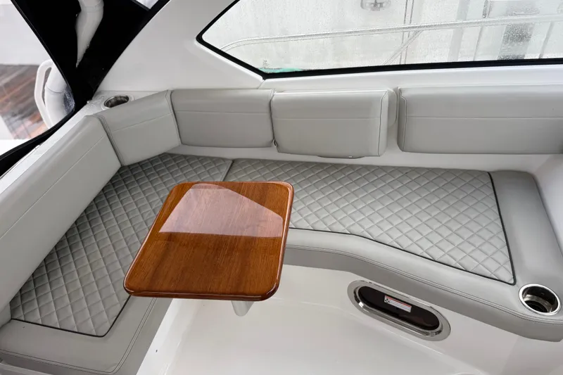 Slide: The Image of Luxurious interior of 2025 Pursuit OS 325 Offshore boat with quilted seating and wooden table. - 29