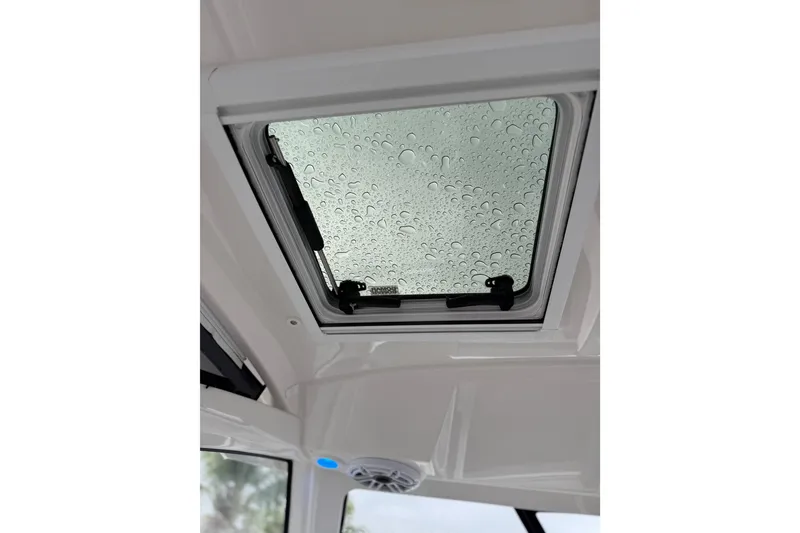Slide: The Image of 2025 Pursuit OS 325 Offshore boat hatch with raindrops on glass. - 37