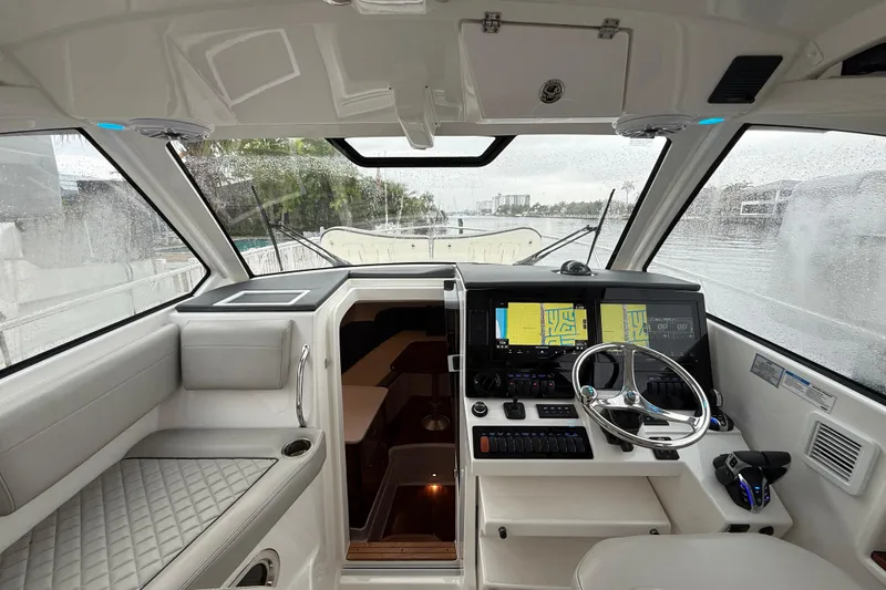 Slide: The Image of Interior of 2025 Pursuit OS 325 Offshore boat with modern navigation system and steering wheel. - 38