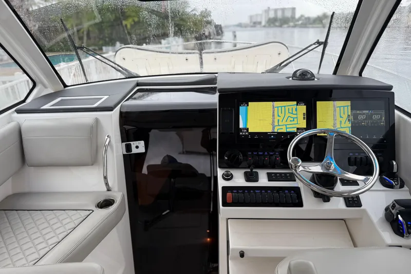 Slide: The Image of 2025 Pursuit OS 325 Offshore helm with dual navigation screens and modern controls. - 39