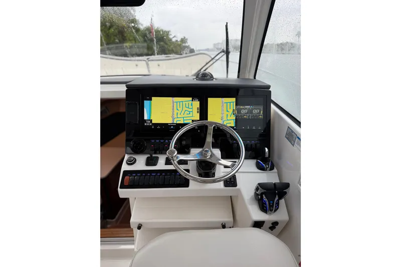 Slide: The Image of 2025 Pursuit OS 325 Offshore helm with dual navigation screens and modern controls. - 42