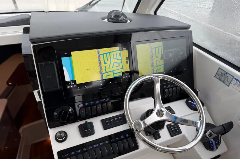 Slide: The Image of 2025 Pursuit OS 325 Offshore helm with dual navigation screens and modern controls. - 43