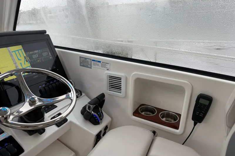 Slide: The Image of Interior of 2025 Pursuit OS 325 Offshore boat with steering wheel and navigation system. - 44