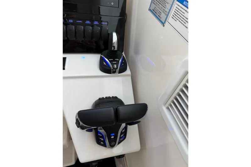 Slide: The Image of 2025 Pursuit OS 325 Offshore boat controls with illuminated buttons and sleek design. - 45