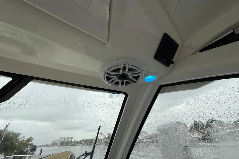 Slide: The Image of Interior view of 2025 Pursuit OS 325 Offshore boat with speaker and raindrop-covered windows. - 51
