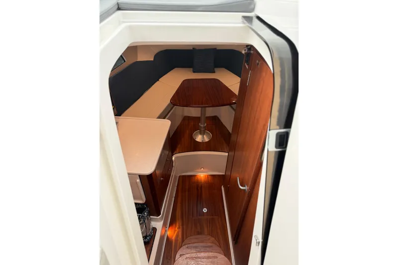 Slide: The Image of 2025 Pursuit OS 325 Offshore cabin interior with wood finishes and seating area. - 53