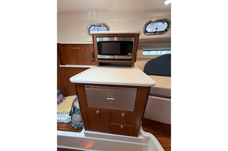 Slide: The Image of 2025 Pursuit OS 325 Offshore interior with microwave and storage cabinets. - 57